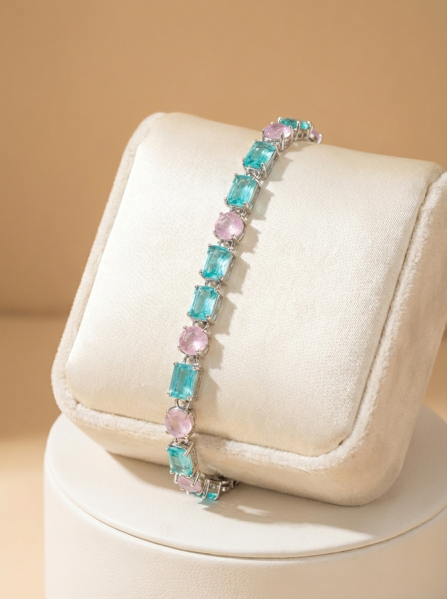 Bracelet with blue and pink gemstones on a beige cushion