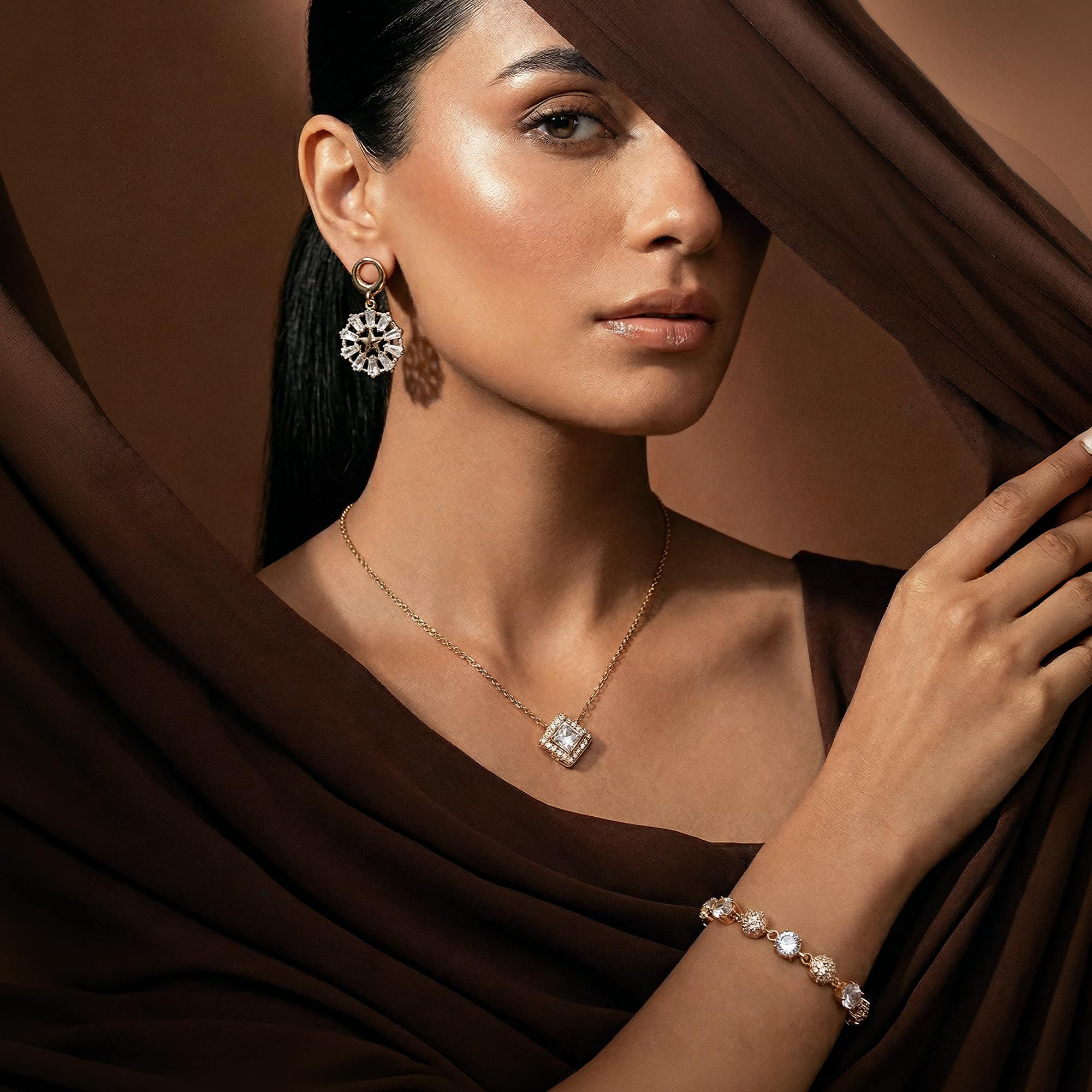 Woman wearing diamond jewelry against a brown background