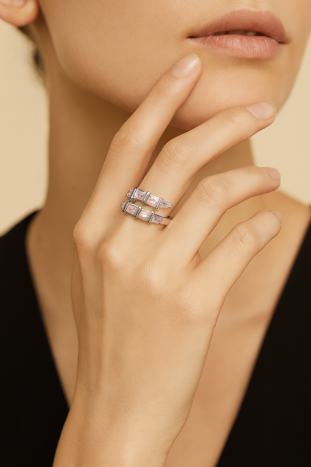 Close-up of a hand wearing two silver rings with a neutral background