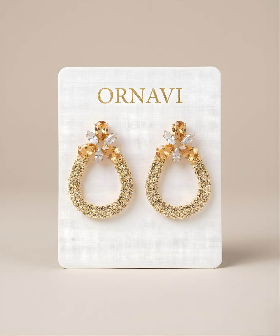 Gold hoop earrings on a white ORNAVI branded card against a beige background