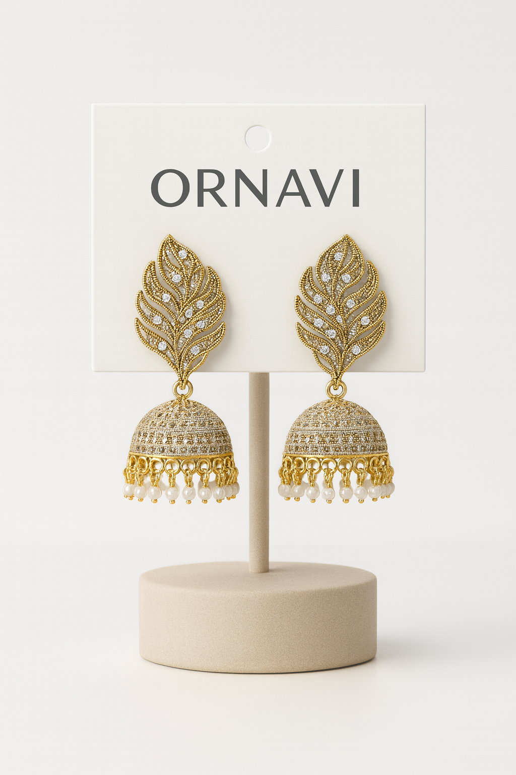 Gold leaf earrings on a display stand with 'ORNAVI' branding on a white background