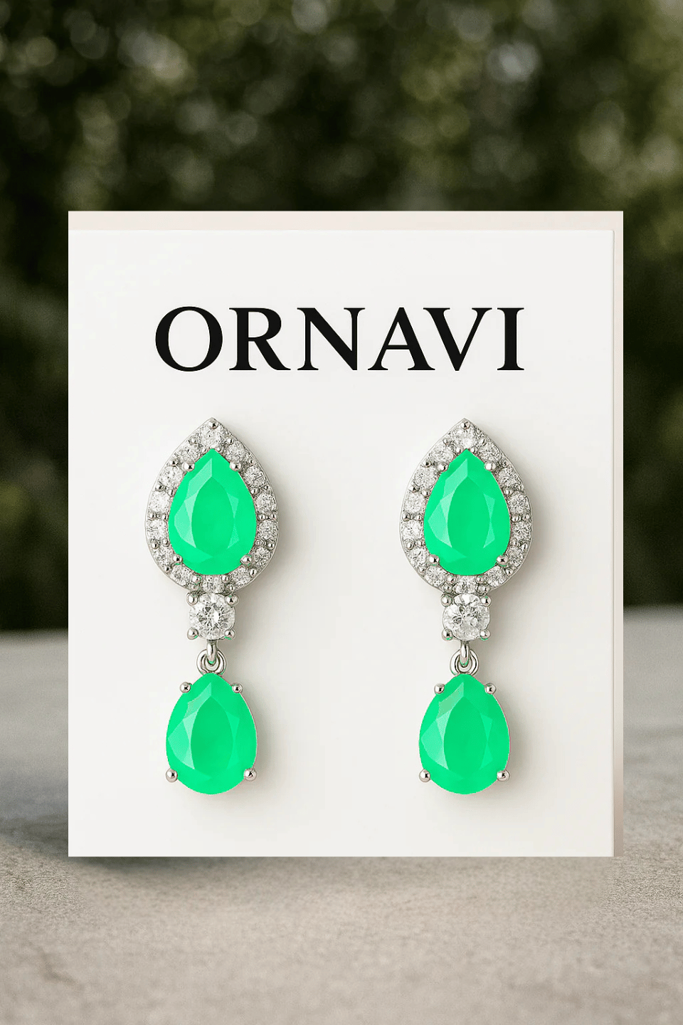 Green teardrop earrings on an ORNAVI branded card with a blurred green background