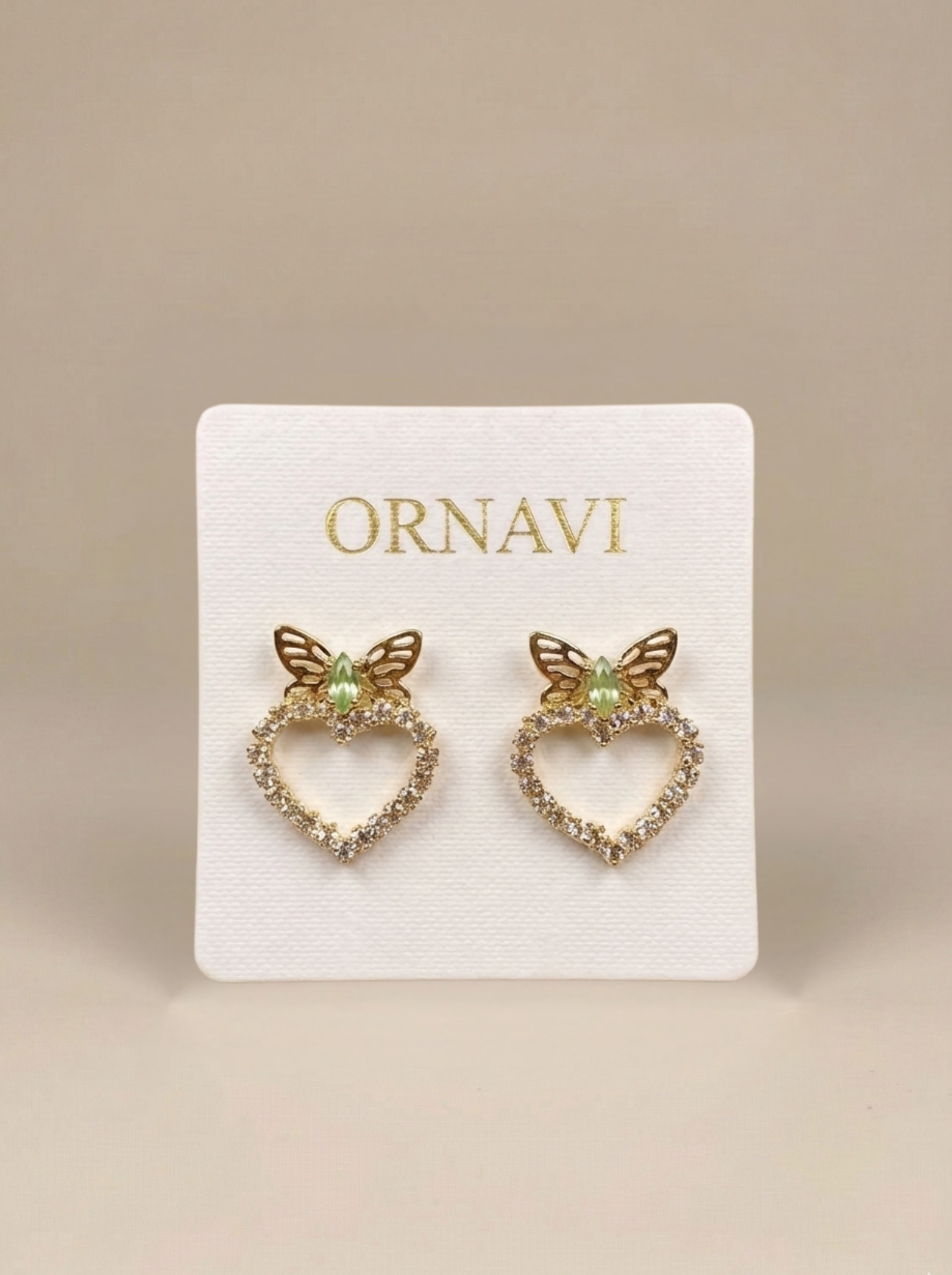 Heart-shaped earrings with butterfly details on a ORNAVI branded card.