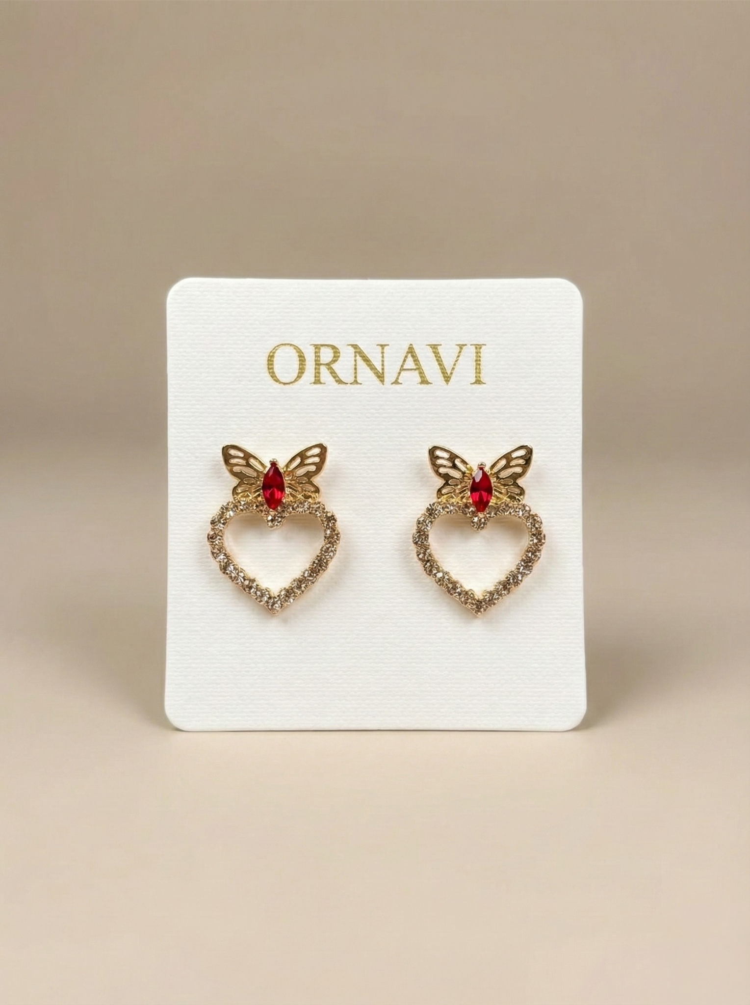 Heart-shaped earrings with butterfly details on an ORNAVI branded card.
