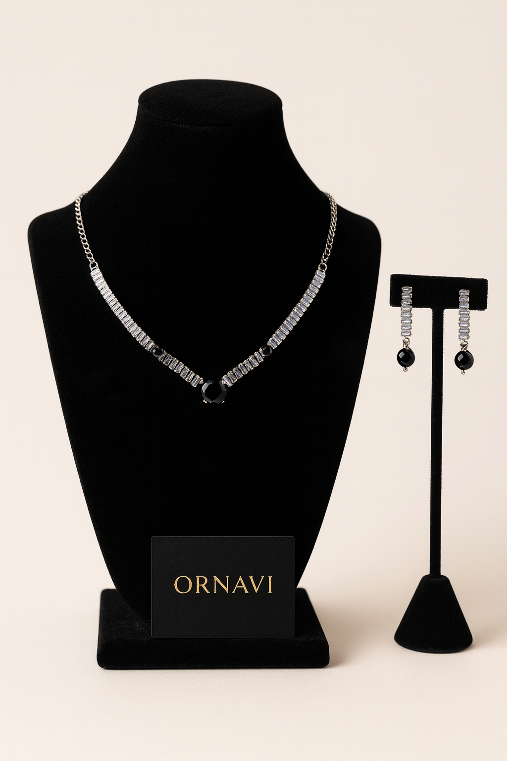 Jewelry set with necklace and earrings on black stands, featuring the brand 'ORNAVI'.