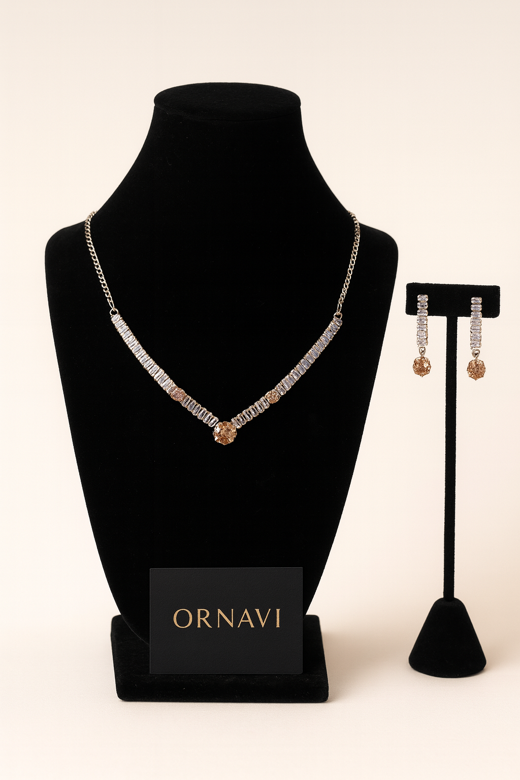 Necklace and earrings on black stands with 'ORNAVI' branding on a beige background