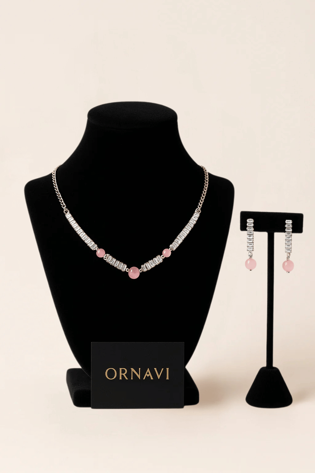 Necklace and earrings on display stands with 'ORNAVI' branding on a beige background