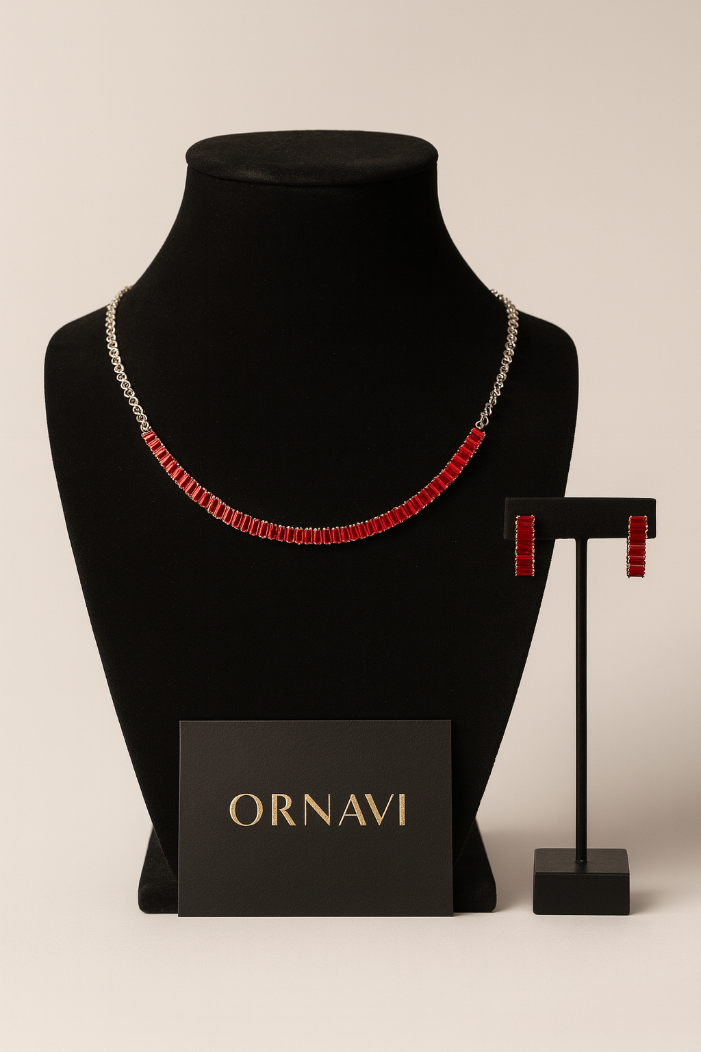 Necklace with red accents on a black mannequin bust, accompanied by a stand with earrings and an ORNAVI card.