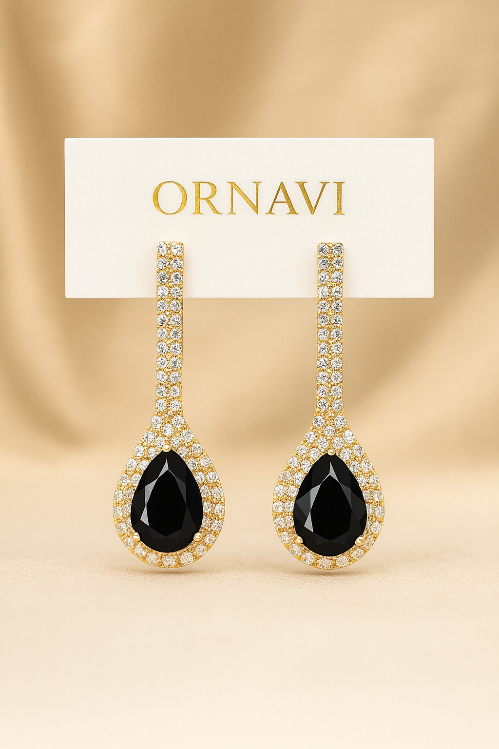 Ornate earrings with black gemstones on a beige background, featuring the brand 'ORNAVI'.