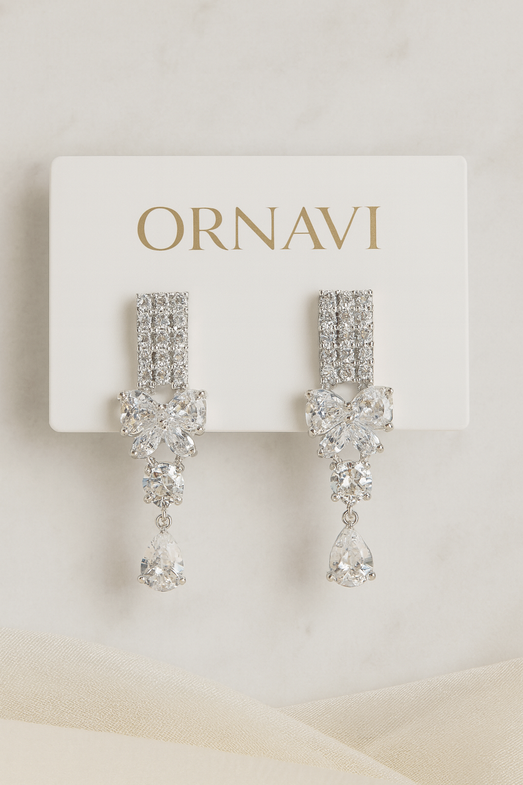 Ornate silver earrings on a white card with 'ORNAVI' branding.