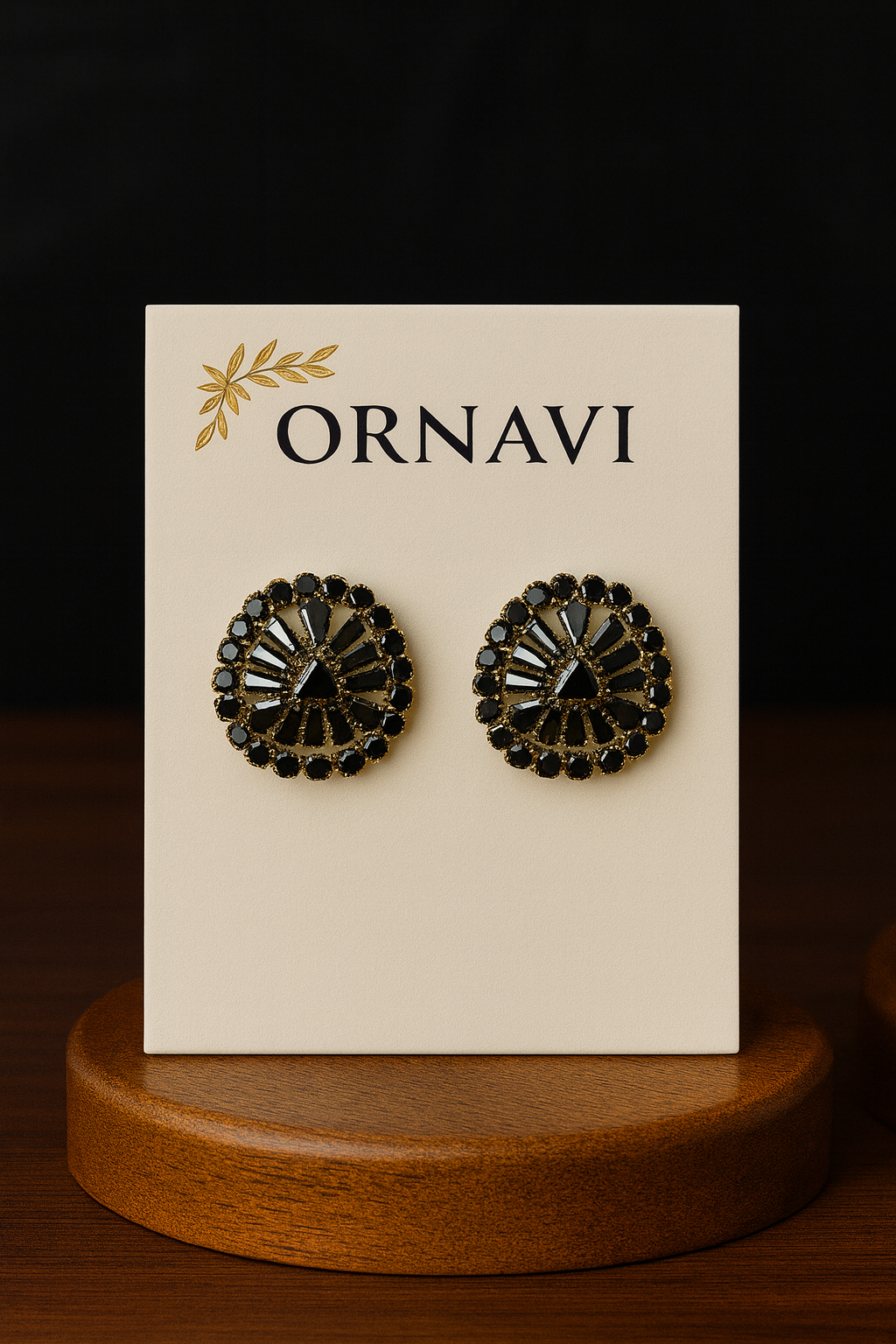 Pair of black earrings on a 'ORNAVI' branded card with a wooden stand.
