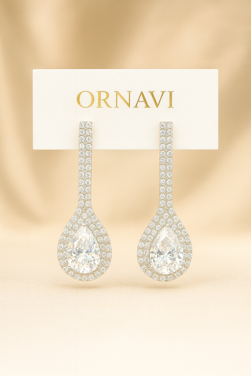 Pair of ornate earrings on a gold background with 'ORNAVI' label.