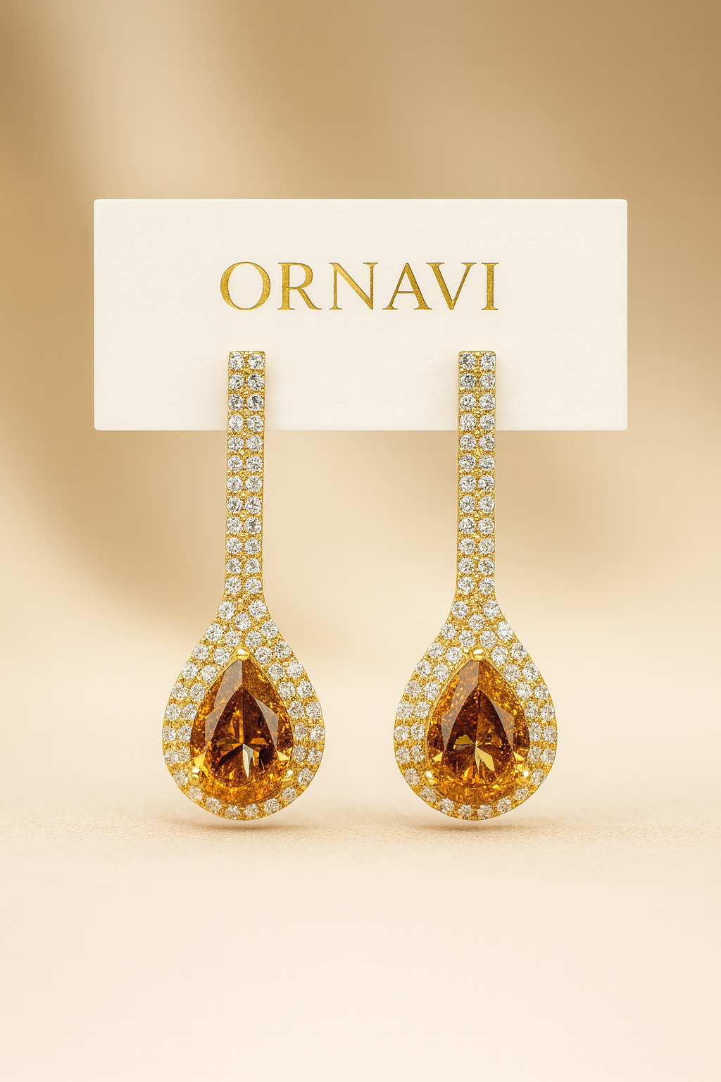 Pair of ornate earrings with ORNAVI branding on a beige background