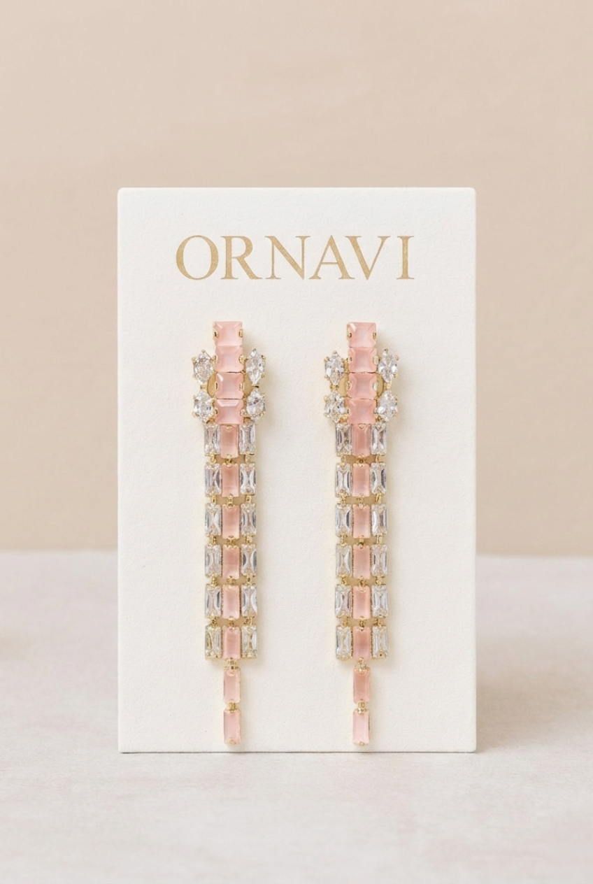 Pink and gold earrings on a white card with 'ORNAVI' branding against a beige background