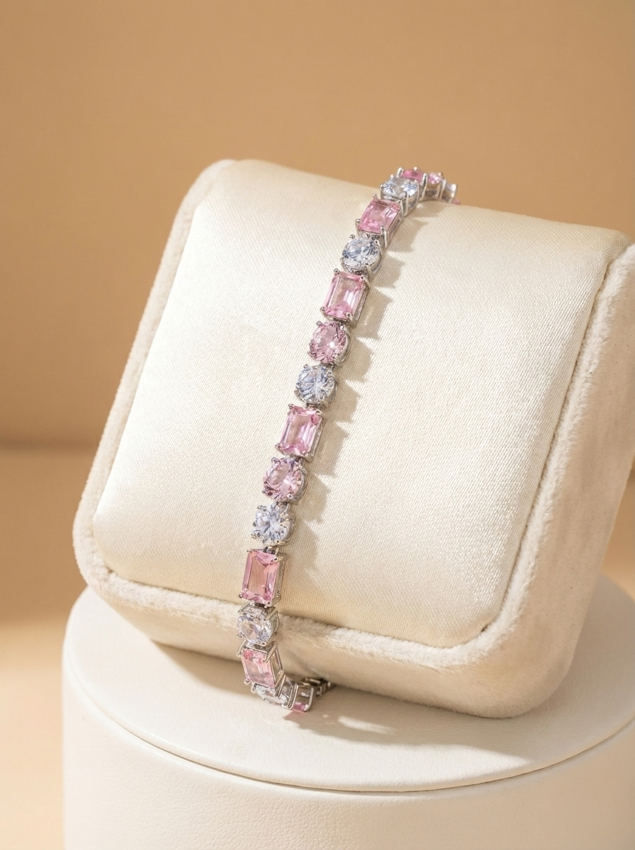 Pink gemstone bracelet on a white cushion against a beige background