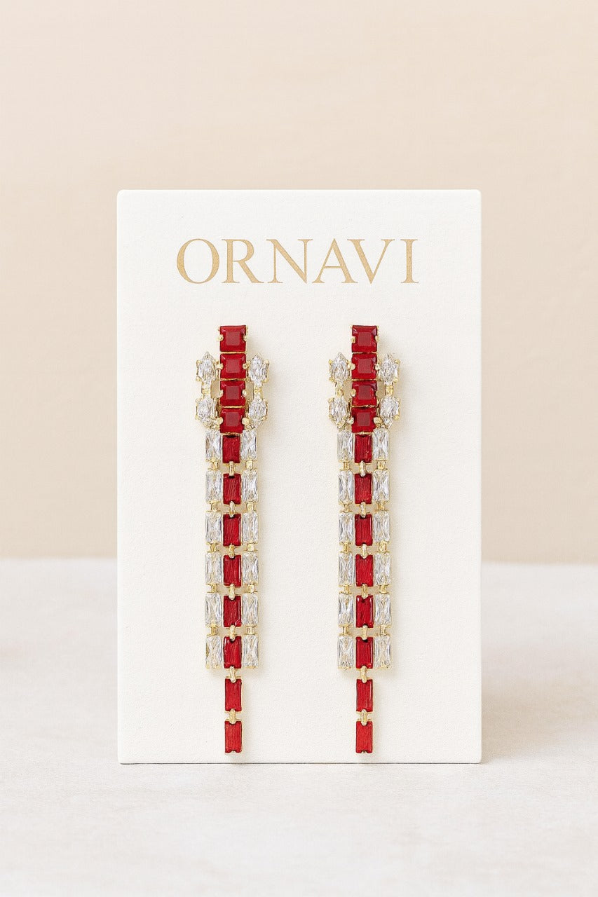 Red and gold earrings on a white card with 'ORNAVI' branding against a beige background
