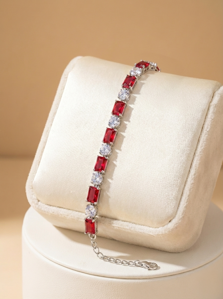 Red gemstone bracelet on a white cushion with a beige background