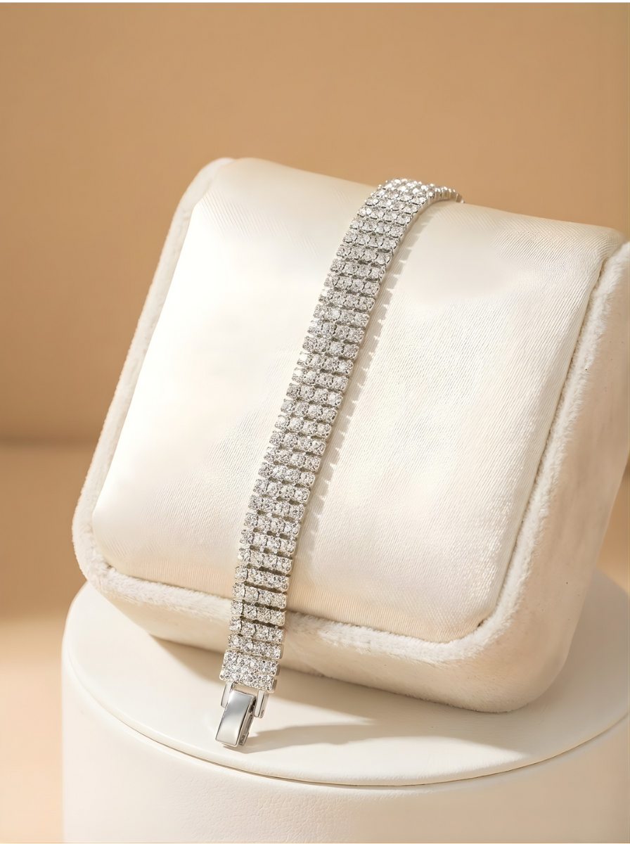 Silver bracelet on a white cushion with a beige background