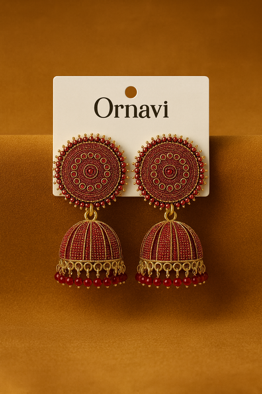 Ornate earrings on a 'Ornavi' branded card against an orange background